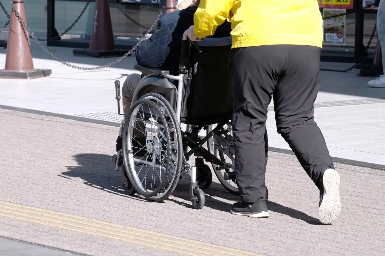 画像：車いすと介助する人