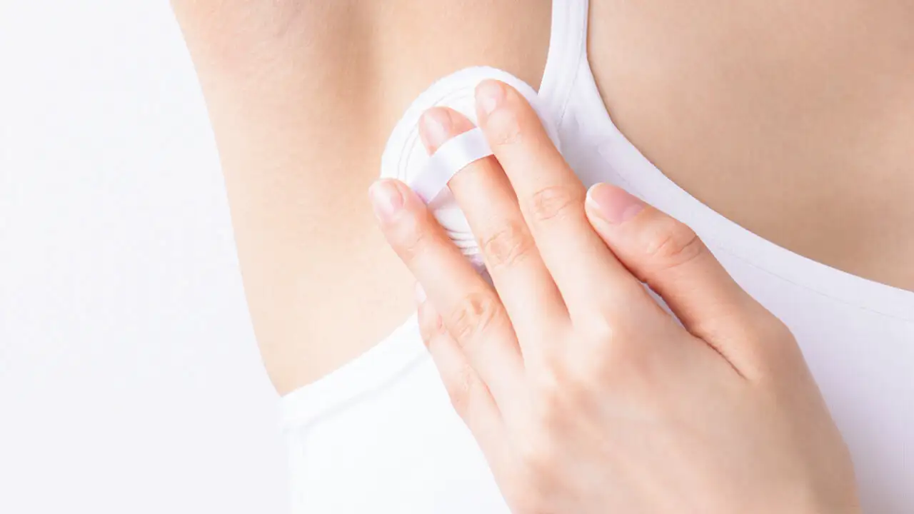  薬用制汗パウダー「さらすず」のパフのヒモに中指を通して人差し指と薬指で押さえる