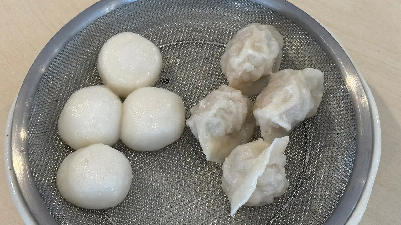 ざるに盛られた茹で肉団子とエビ入り水餃子