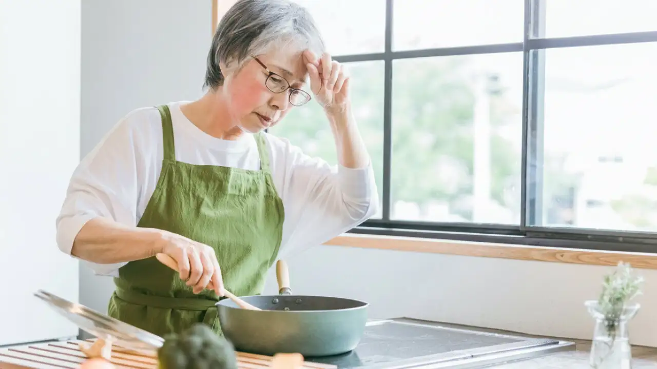 画像：台所で暑がっている女性
