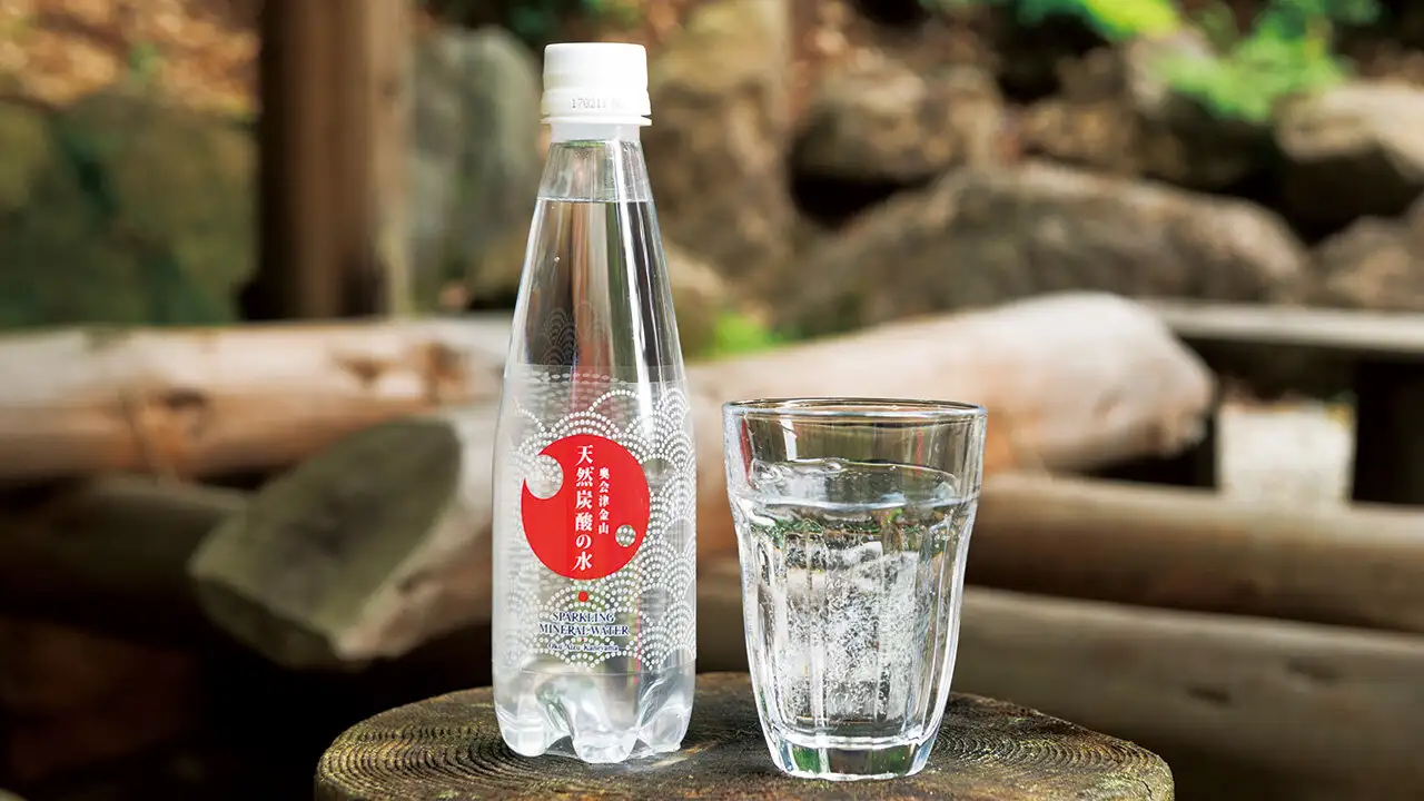 商品『天然炭酸の水』のペットボトルと、グラスに注がれた炭酸水。