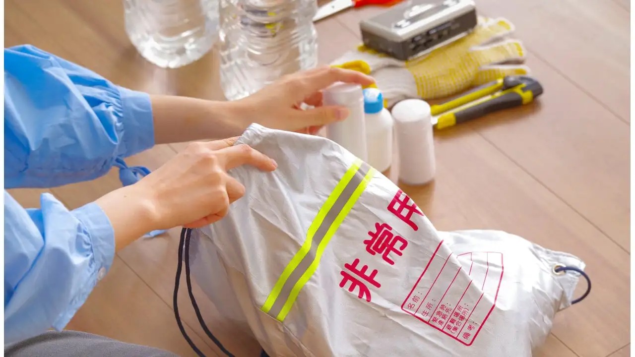 「非常用」と書かれた巾着を開け、防災用品を準備している女性