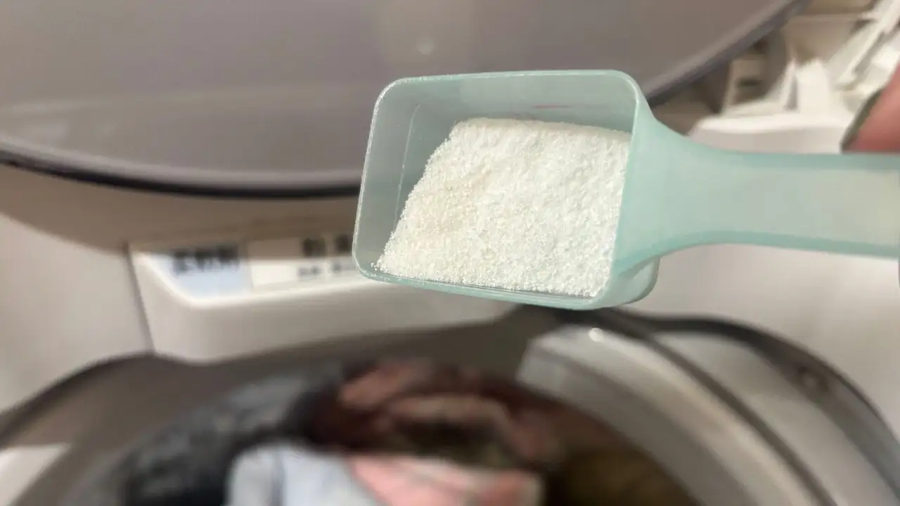 画像：洗濯機の前でゼロノンウォッシュをスプーンに入れている様子