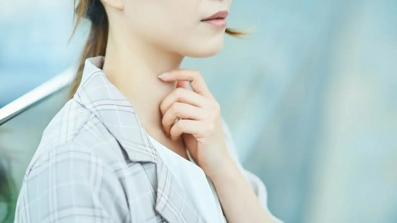 画像:のどを抑える女性の様子