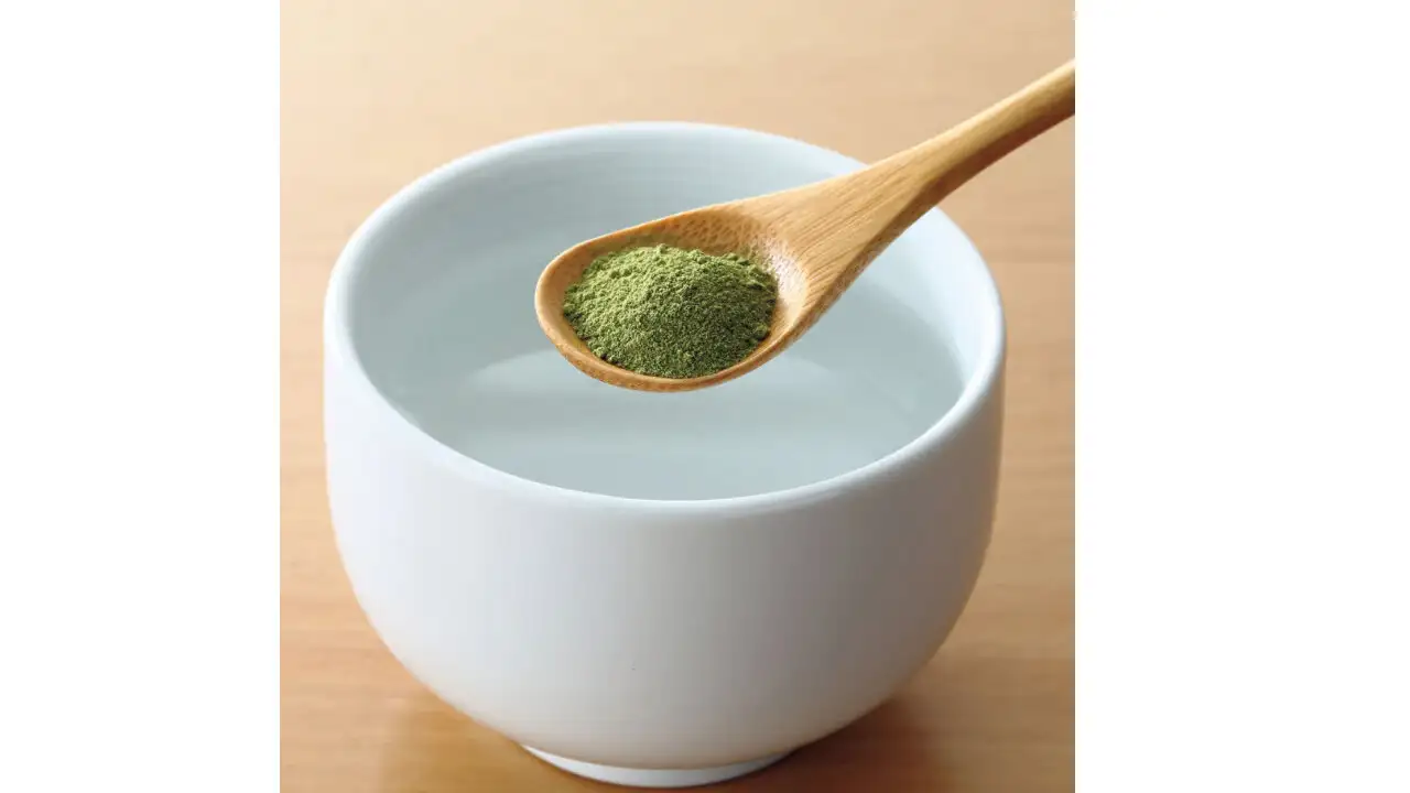 画像：緑茶の粉末を湯呑の入れる様子