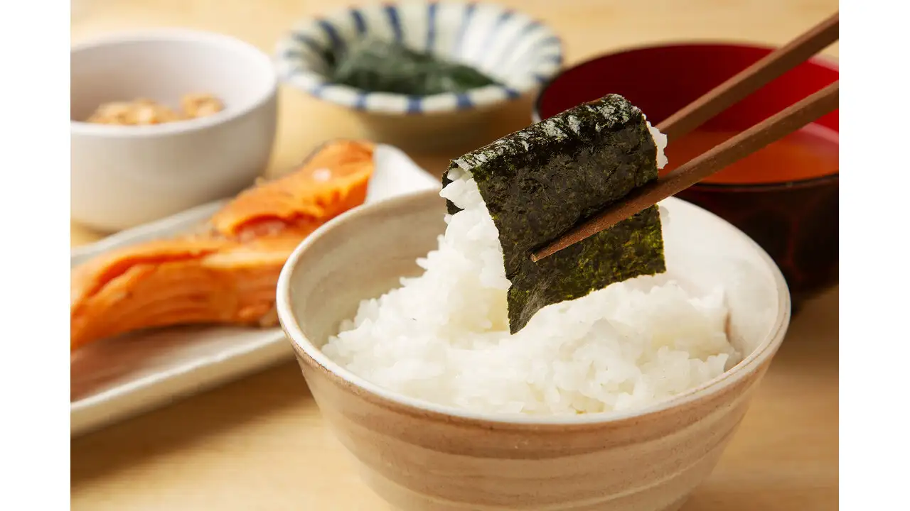 味付け海苔とご飯の朝食。奥には焼き鮭と小鉢、汁物がある