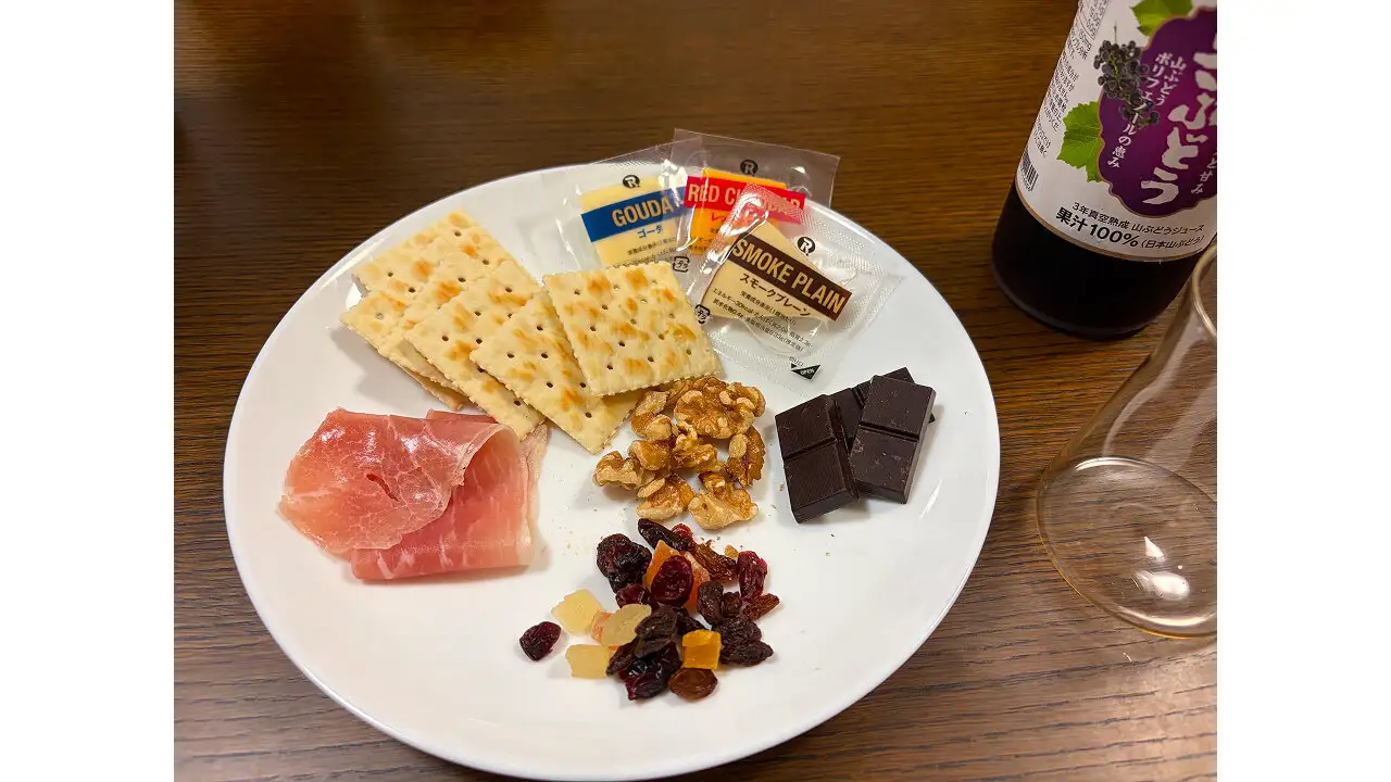 左上から時計回りに、クラッカー、3種のチーズ、ハイカカオチョコレート、ドライフルーツ、生ハム。中央にくるみ