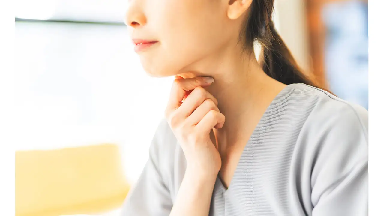 のどを気にしている女性