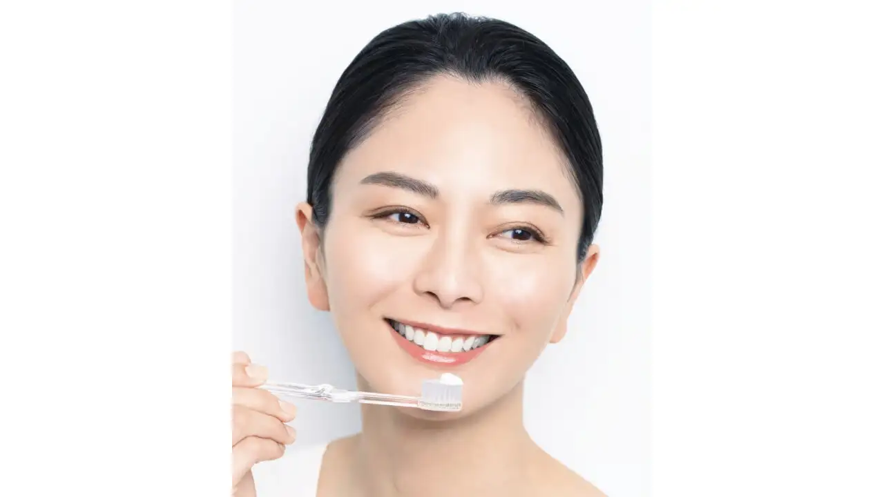 商品『白絹練』を使って歯を磨くモデル女性
