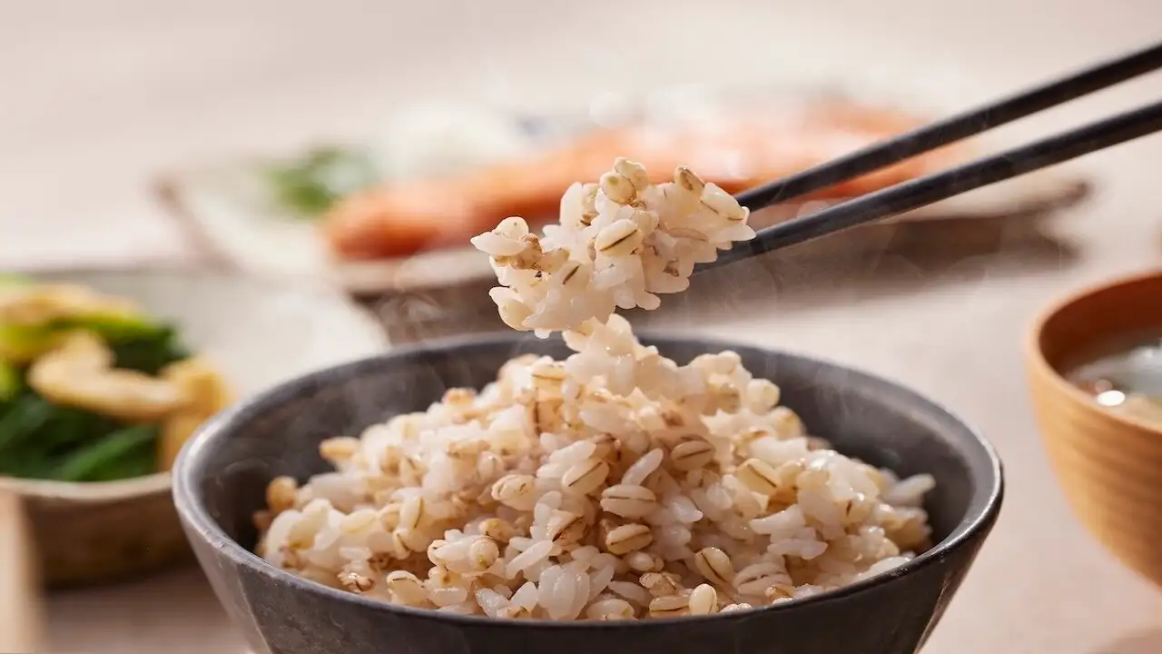 麦ごはんを箸ですくう