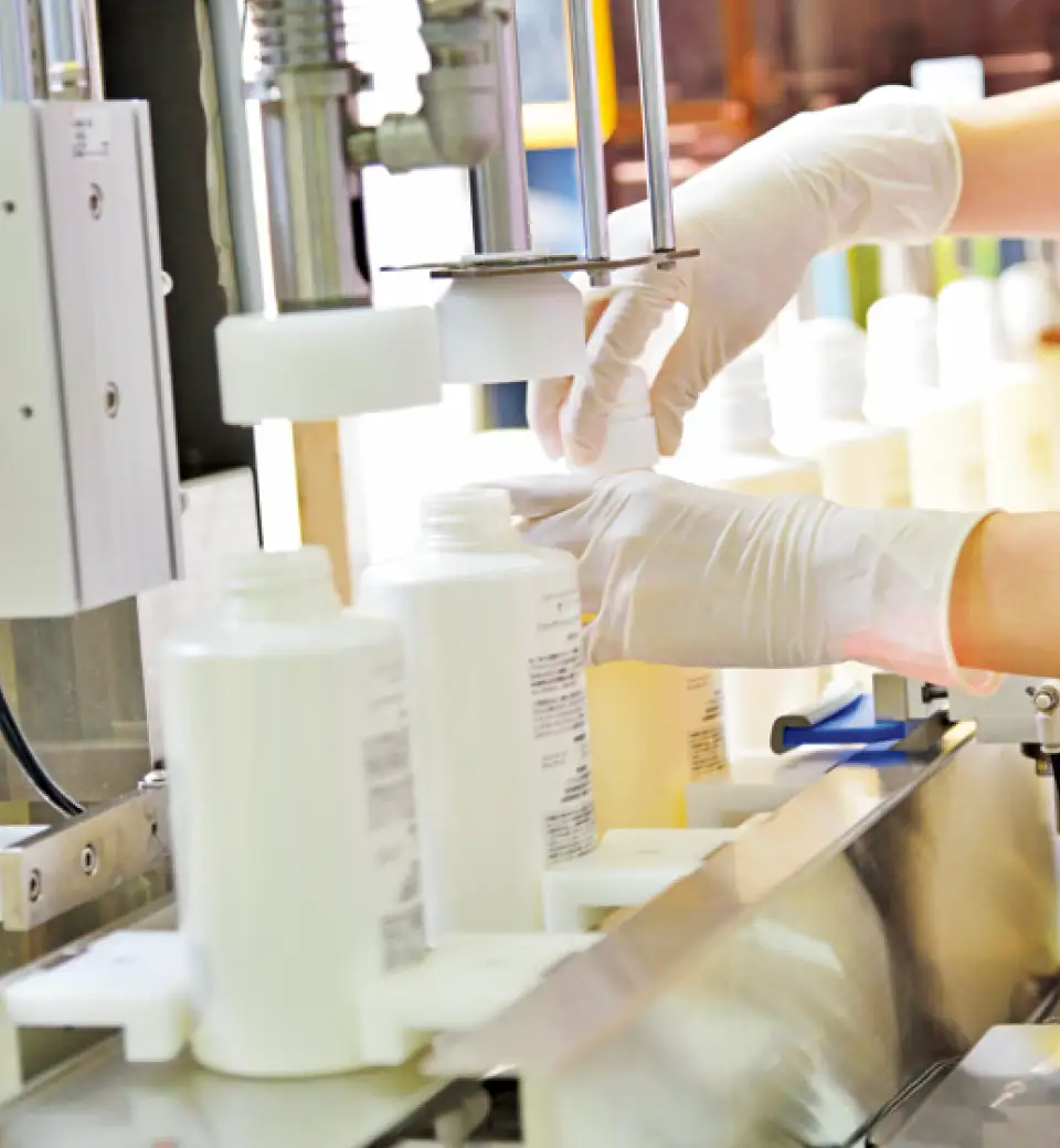 容器に傷がないか目視でチェックする。異物混入がないか確認後充填。その後、化粧箱に封入され重量を計測。出荷される　イメージ