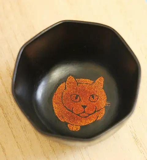 蒔絵に漆を摺り込んで固める。飴色の漆を上塗りして研ぐ イメージ